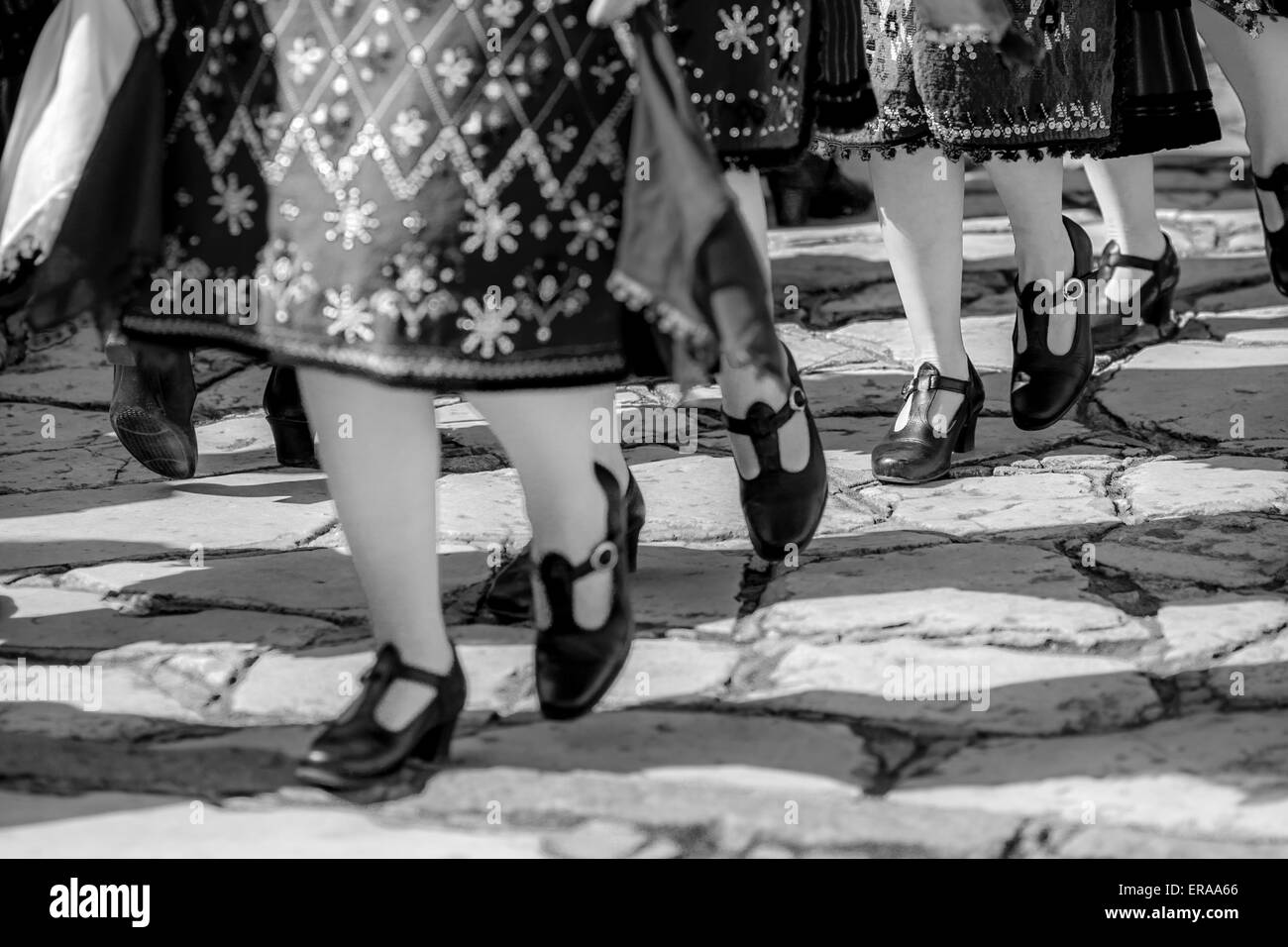 Feet of female Bulgarian folklore dancers during the traditional folklore festival '1000 national costumes' in black and white Stock Photo