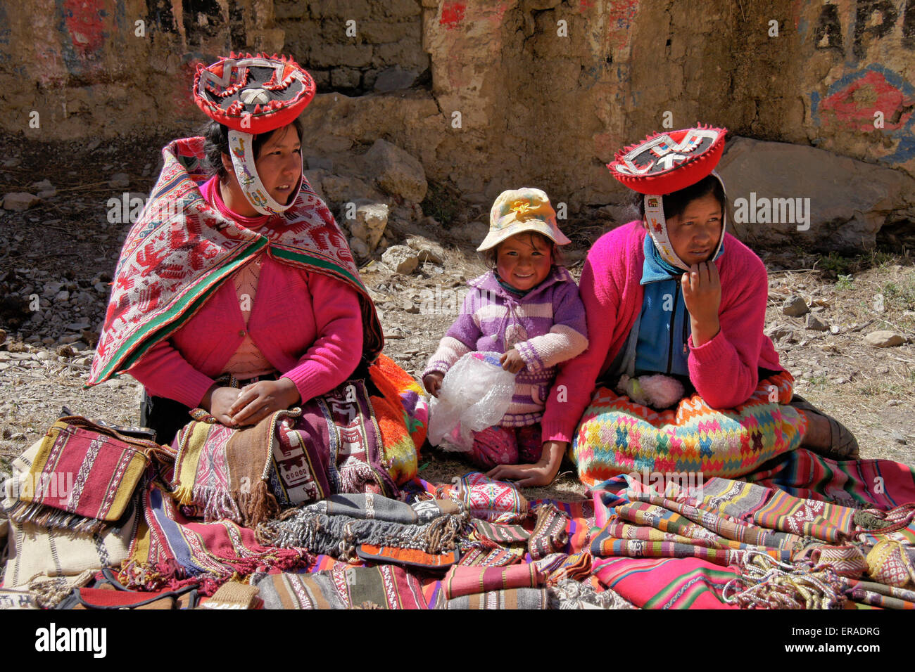 Quechua Indian women and child selling woven goods, Patacancha, Peru Stock Photo