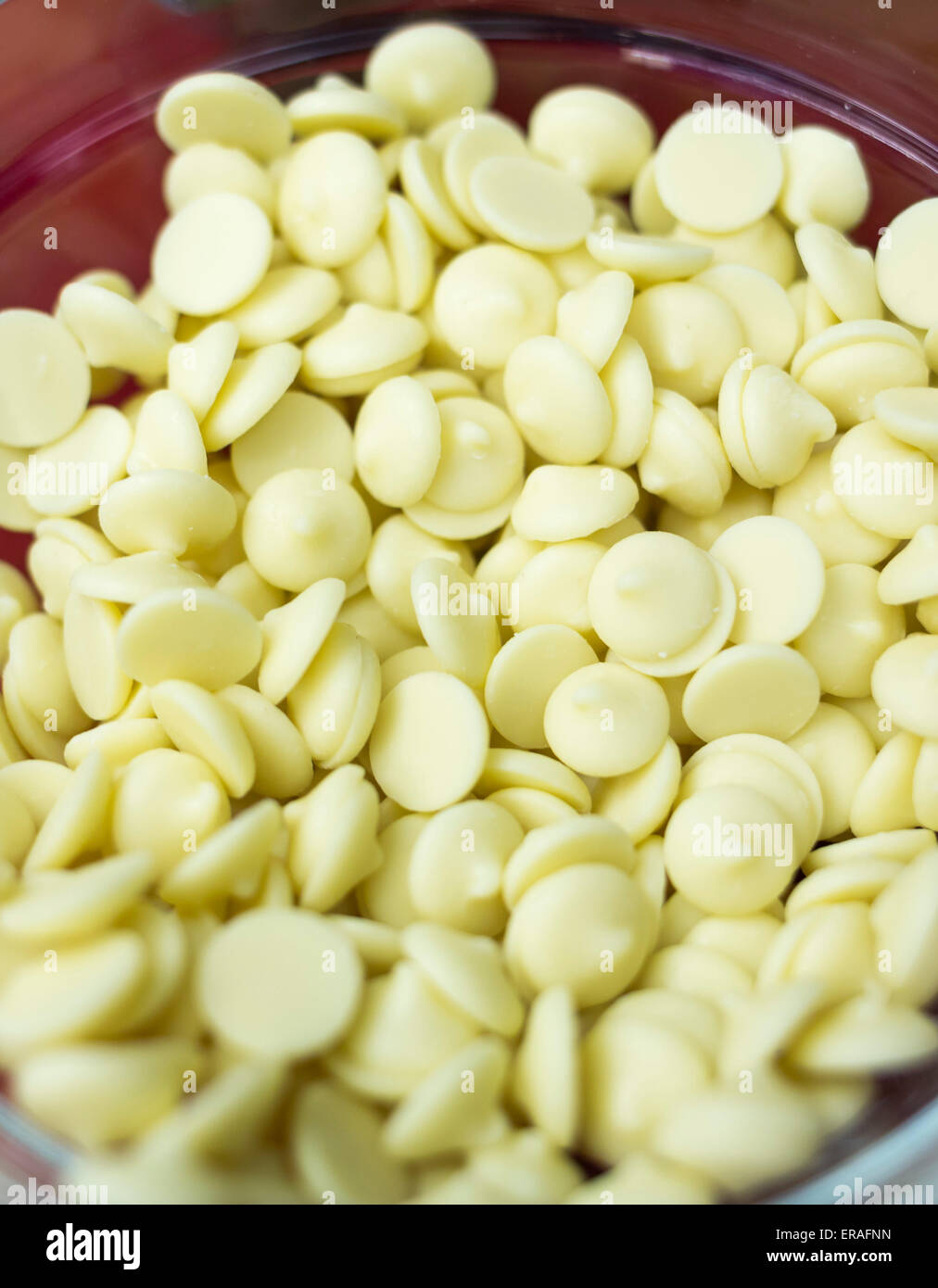 White chocolate chips for sweets decoration in a cup. Stock Photo