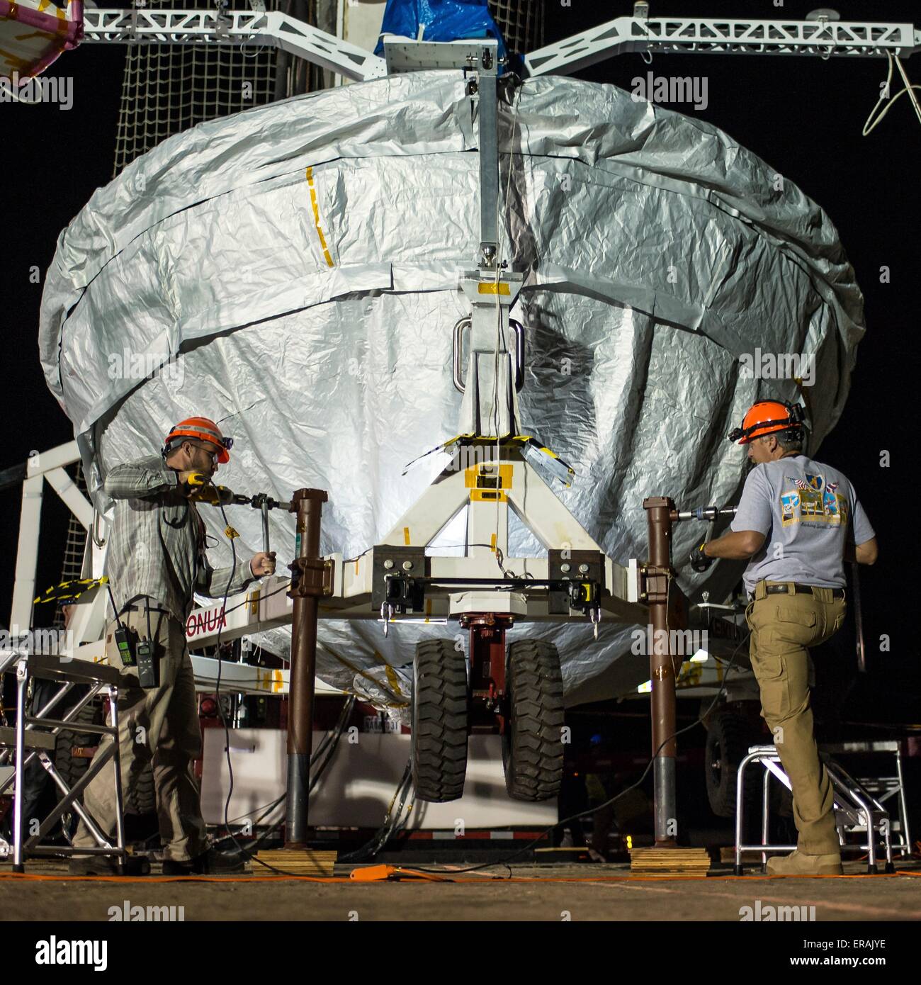 NASA engineers prepare the Low-Density Supersonic Decelerator to be lifted into position for a full mission dress rehearsal at the U.S. Navy Pacific Missile Range Facility May 29, 2015 in Kauai, Hawaii.  The LDSD tests new concepts in entry, descent and landing of spacecraft safely on the surface of Mars. Stock Photo