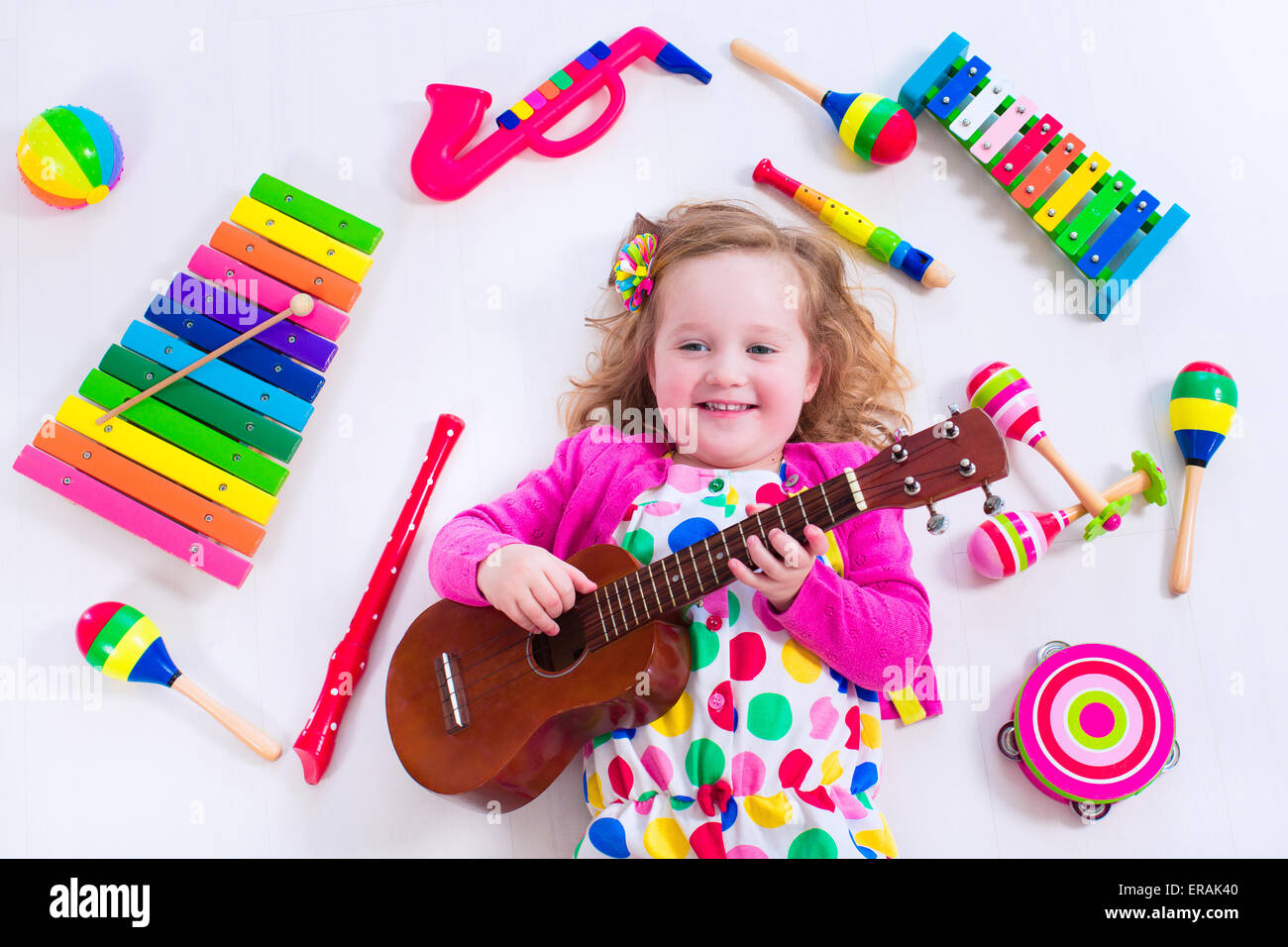 Child with music instruments. Musical education for kids. Colorful wooden art toys for kids. Little girl playing music. Stock Photo