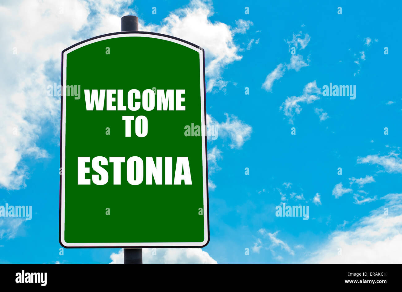 Green road sign with greeting message WELCOME TO ESTONIA isolated over clear blue sky background with available copy space. Trav Stock Photo
