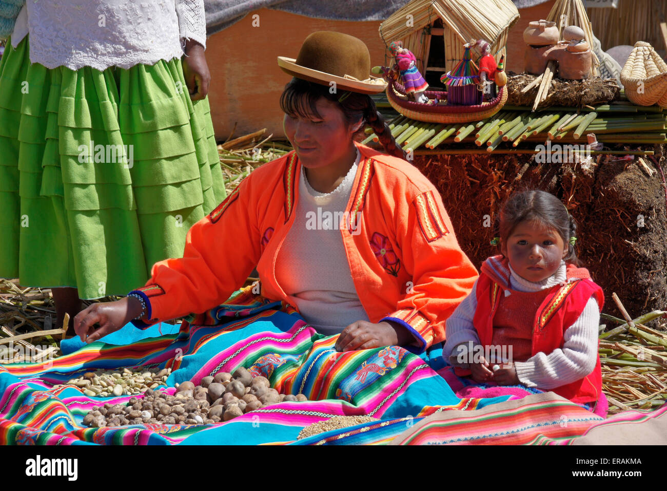 Uros Indian woman and child with potatoes, Titino floating island (Puno), Lake Titicaca, Peru Stock Photo