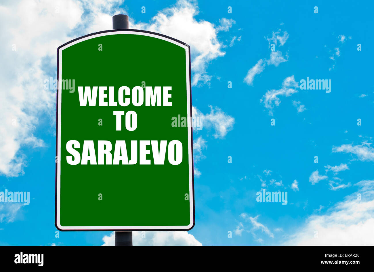 Green road sign with greeting message WELCOME TO SARAJEVO isolated over clear blue sky background with available copy space. Stock Photo