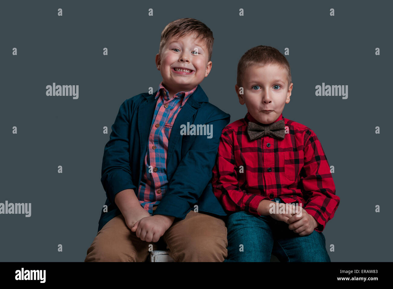 two little boys with emotion on her face isolated on dark background Stock Photo