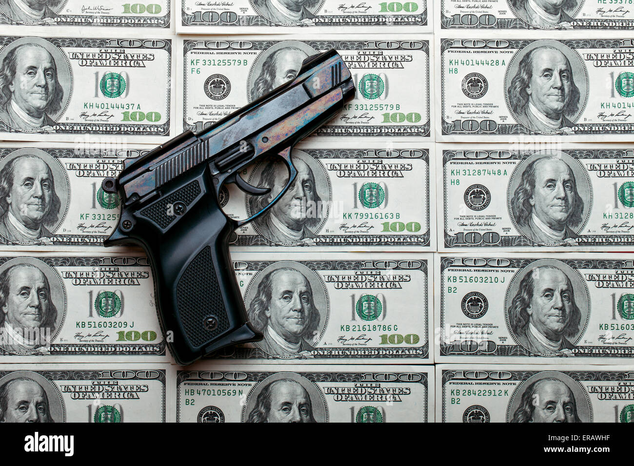 Black gun on the background of packs with money Stock Photo  Alamy