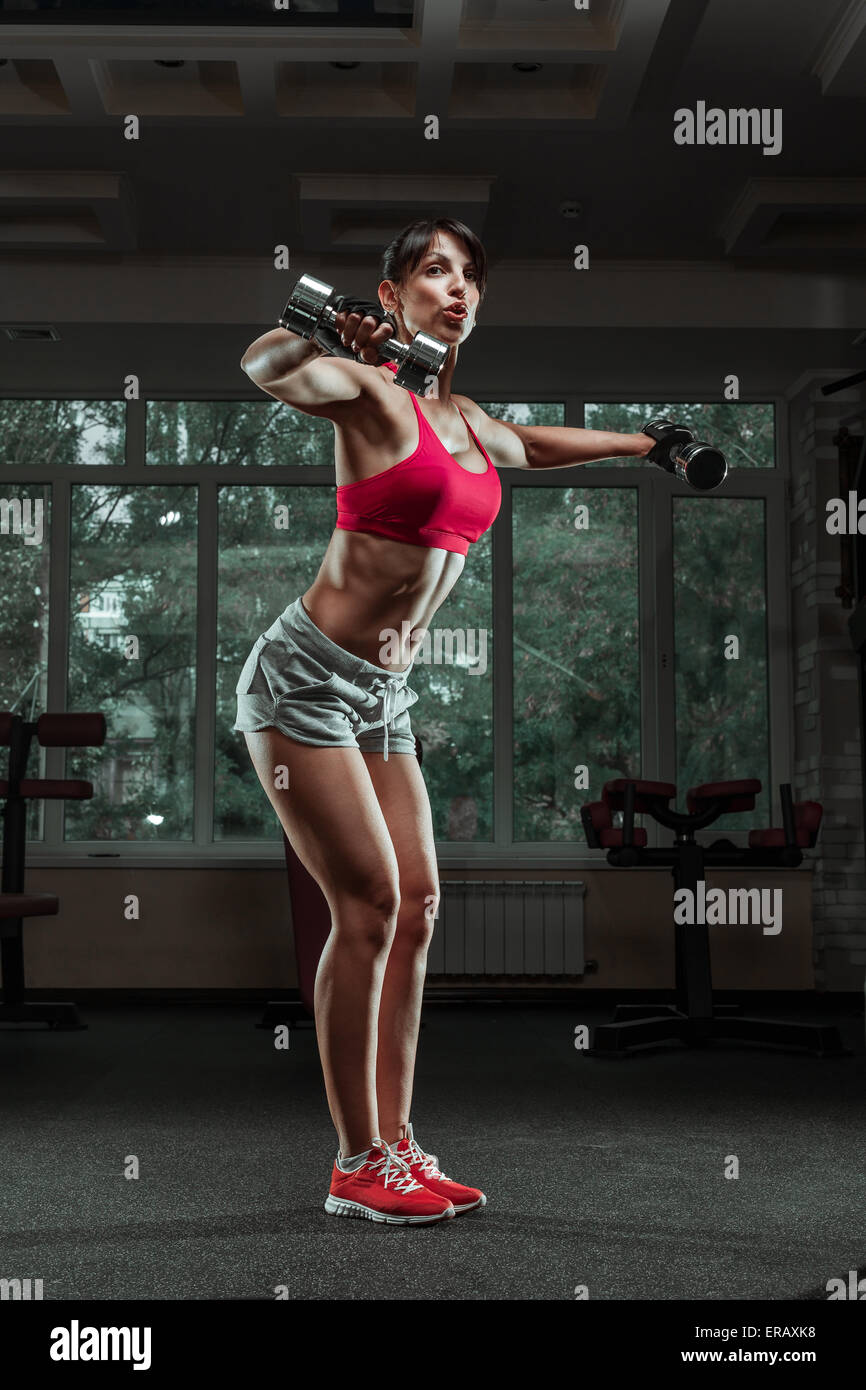 Sporty girl doing exercise with dumbbells in the gym Stock Photo
