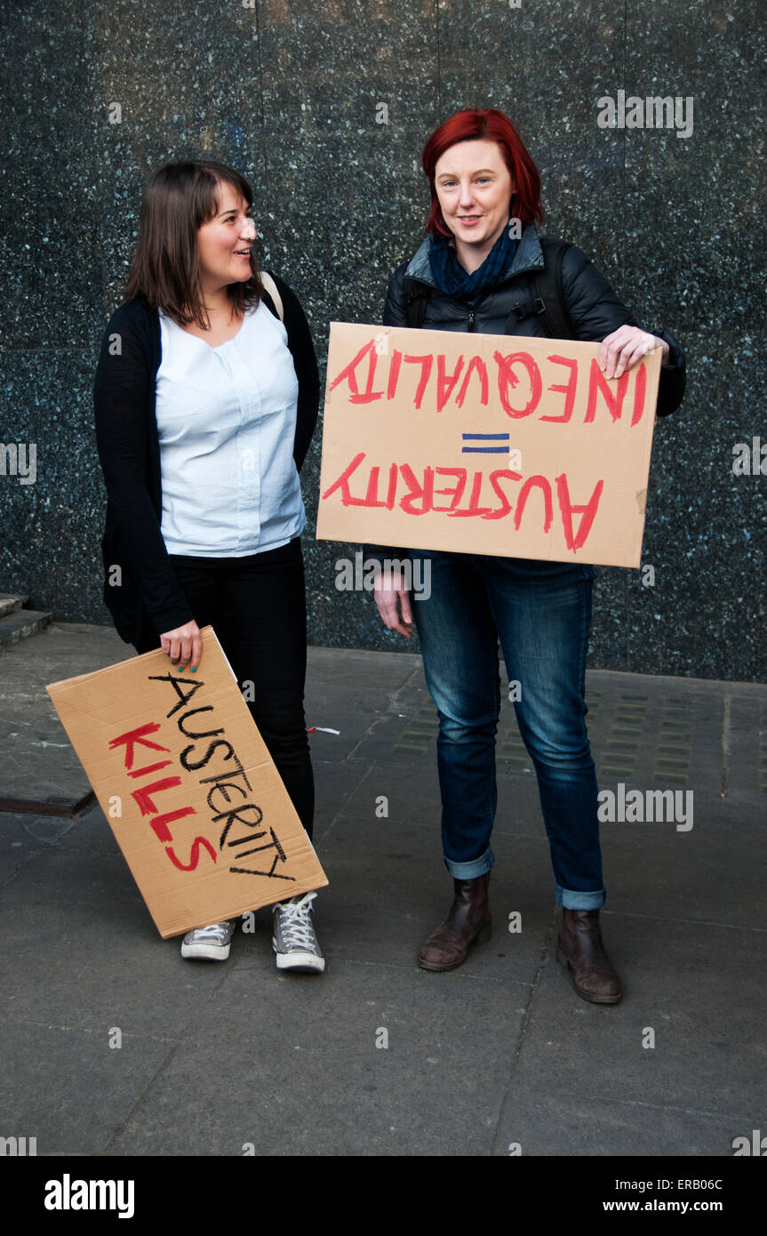 Protest against austerity organised by UK Uncut May30th 2015. Two young women with cardboard signs saying 'Austerity kills' and Stock Photo