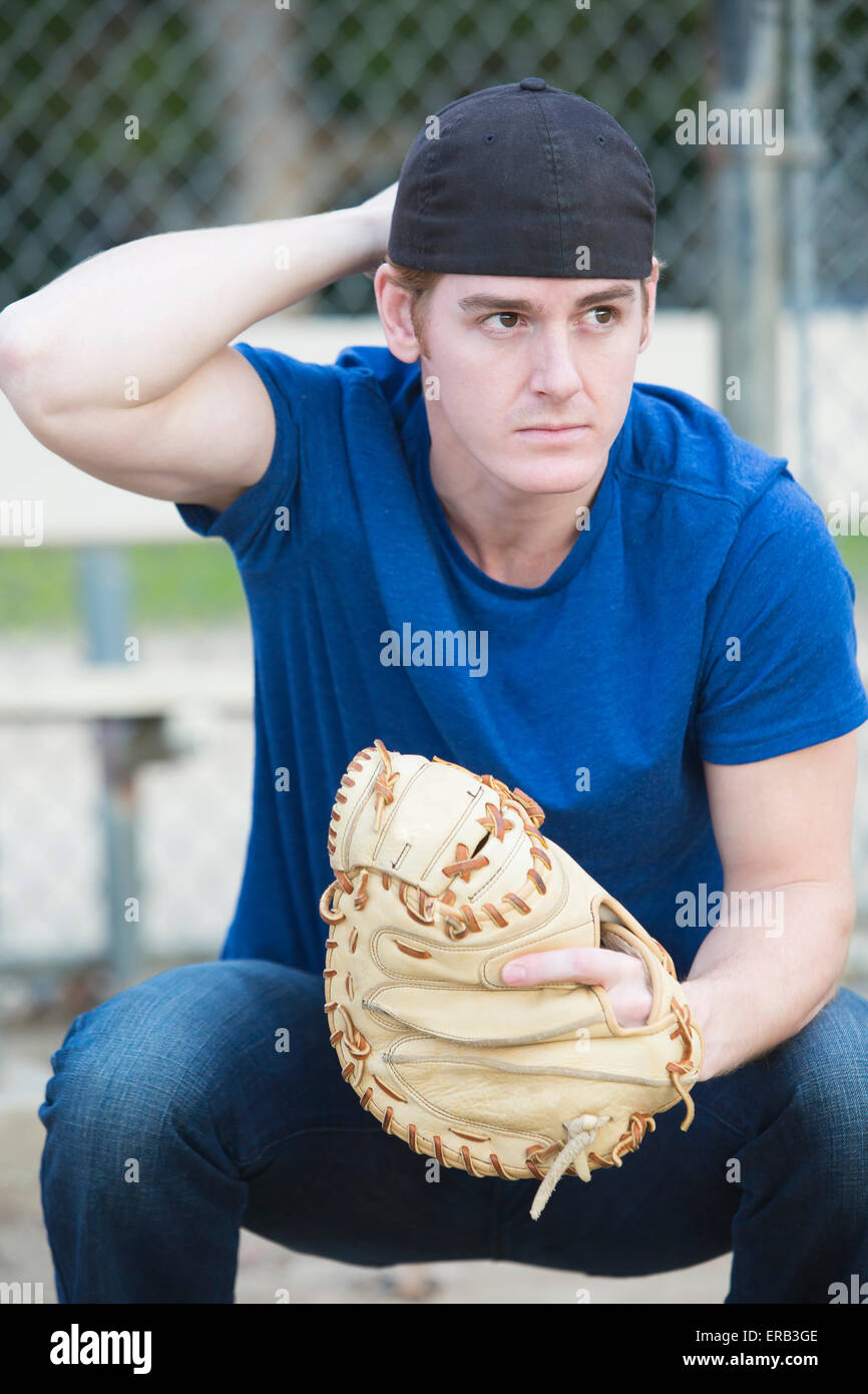 young man with baseball glove on a sports field Stock Photo