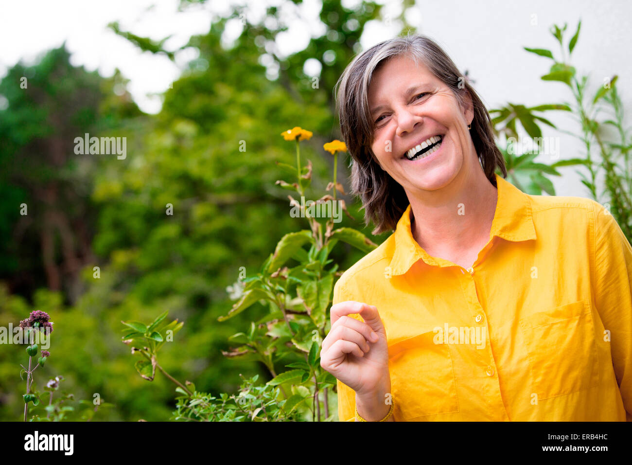 portrait of an older woman on her balcony and smiling Stock Photo - Alamy