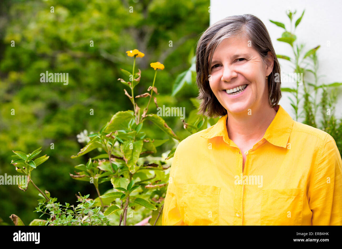 portrait of an older woman on her balcony and smiling Stock Photo - Alamy