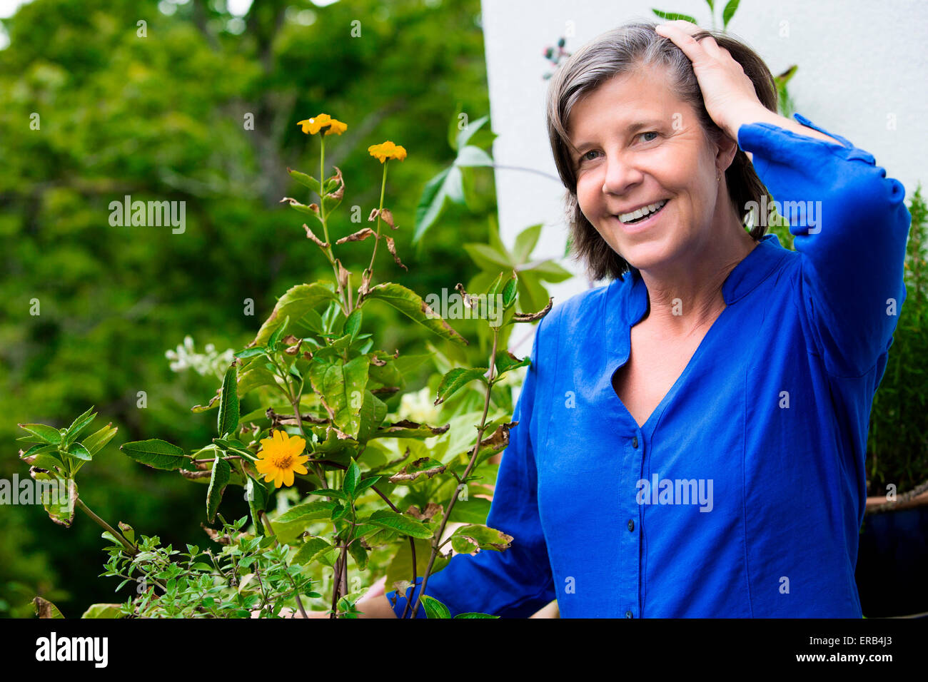 portrait of an older woman on her balcony and smiling Stock Photo - Alamy