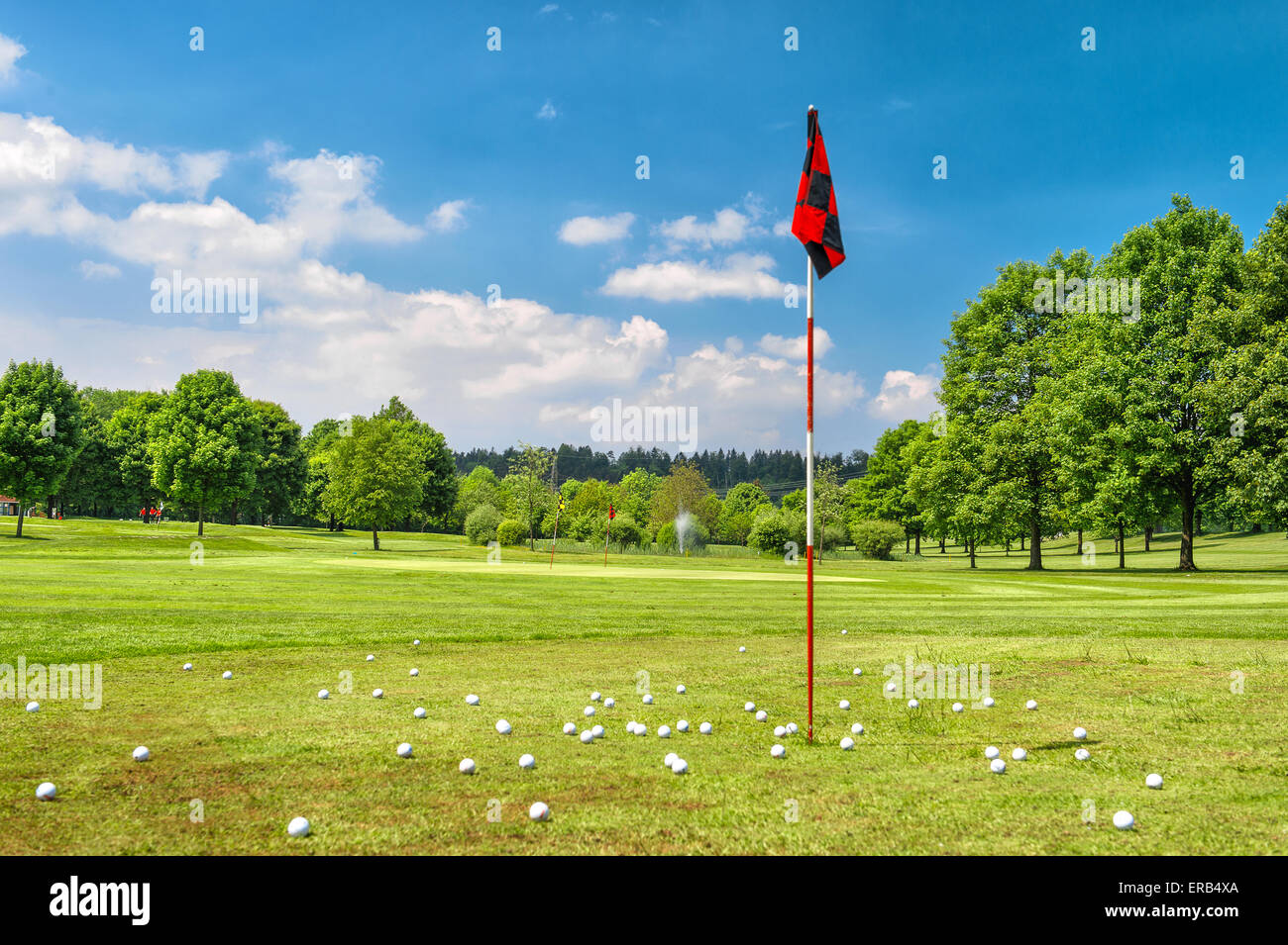 Golf field and cloudy blue sky. European spring landscape with green grass and trees Stock Photo