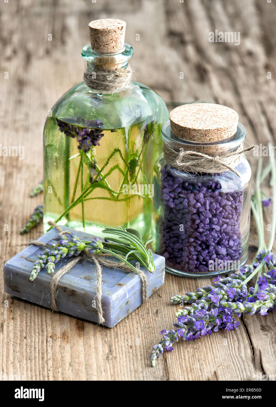 Lavender essential oil, herbal soap and bath salt with fresh flowers on wooden background Stock Photo