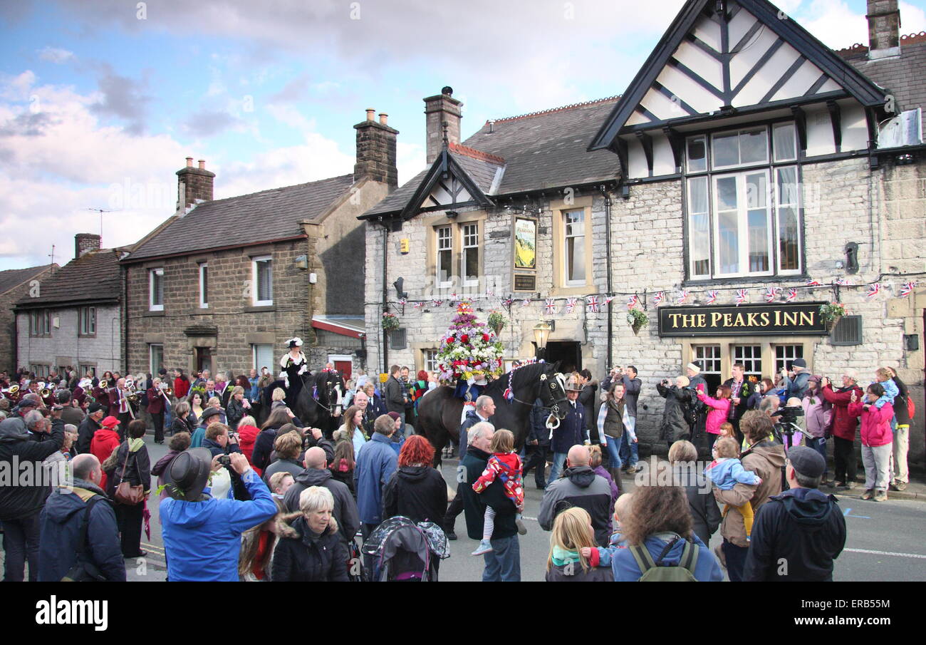 Wearing a floral headdress, the Garland King processes through Castleton in the Peak District in celebration of Oak Apple Day UK Stock Photo