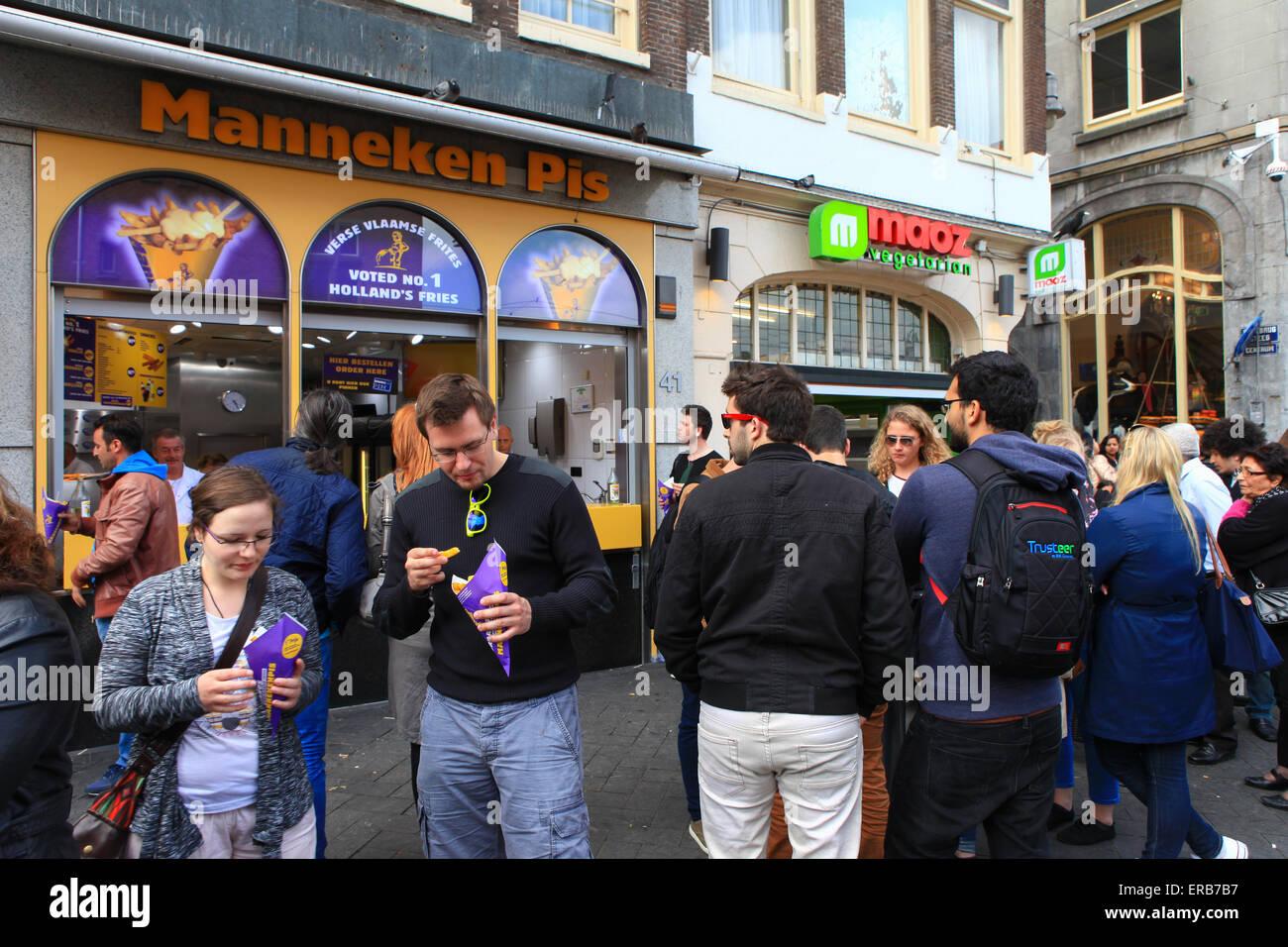Locals and tourist at Amsterdam's famous Manneken pis dutch fries fast food shop. Stock Photo