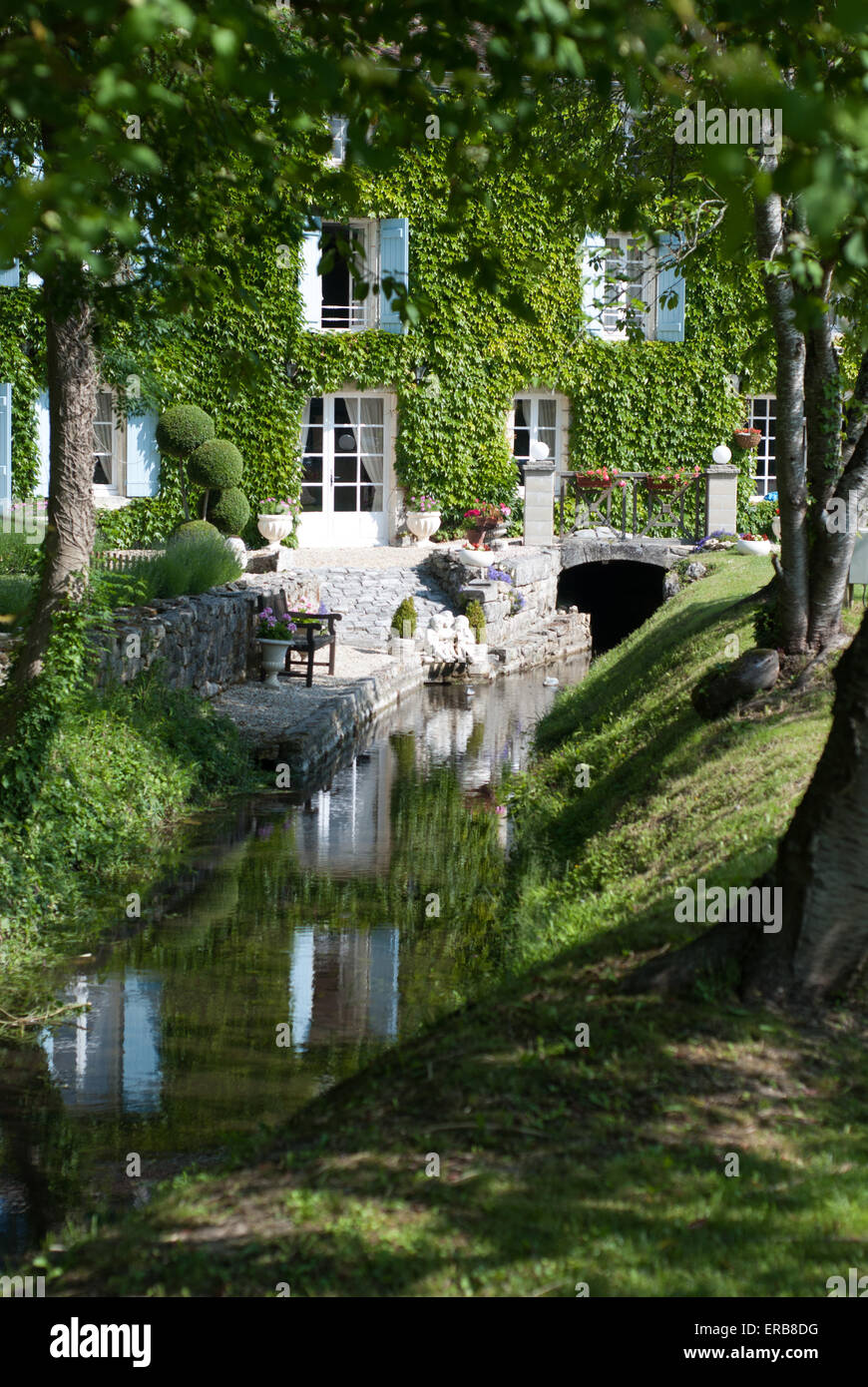 French country house with a stream running through it to a water mill Stock Photo