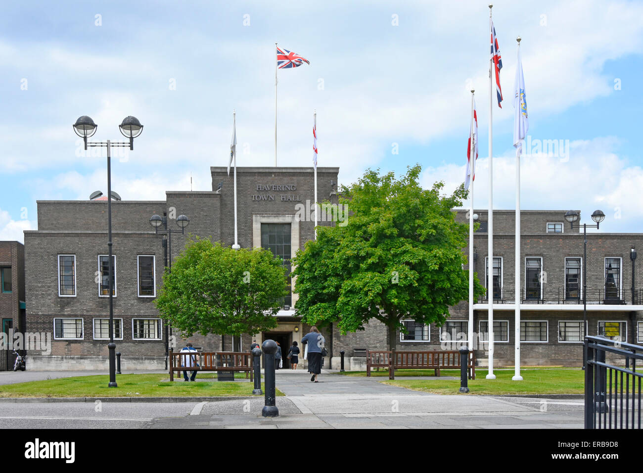 People walking towards East London Borough of Havering town hall council offices in a municipal building Union Jack flying in Romford England UK Stock Photo
