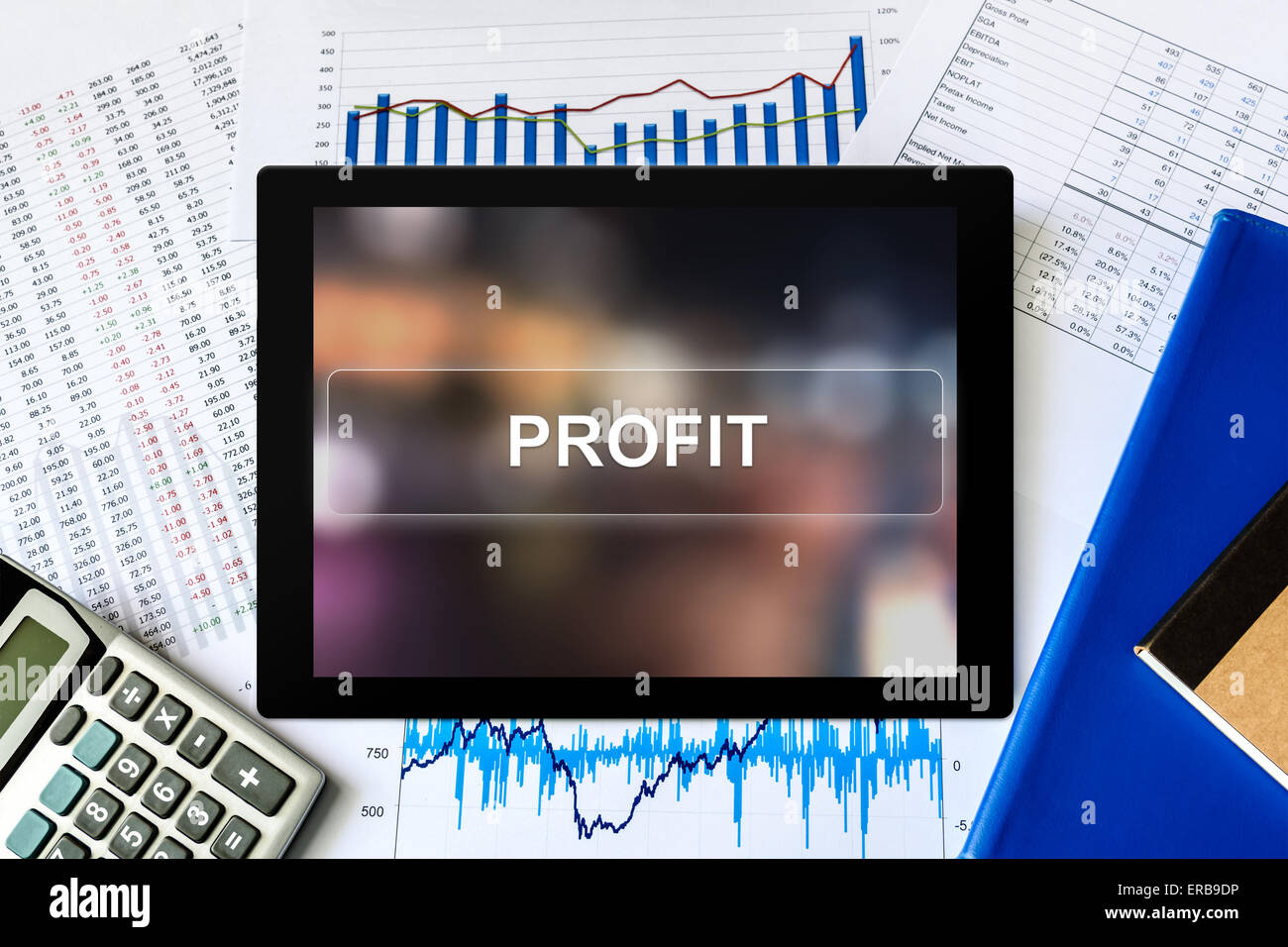 financial profit word on tablet with financial graph background Stock Photo