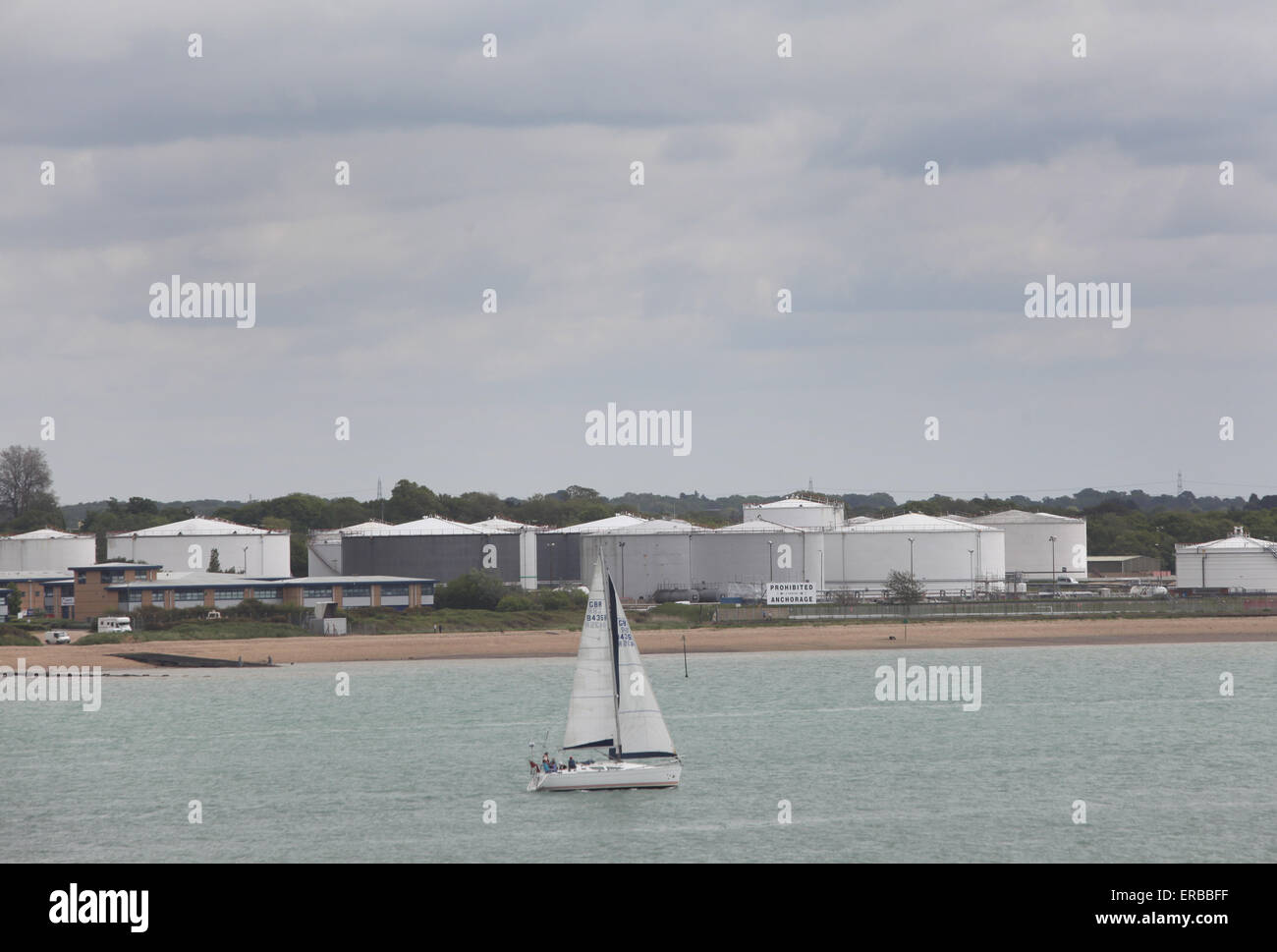 a yacht sailing past BP oil terminal in Hamble le Rice Stock Photo