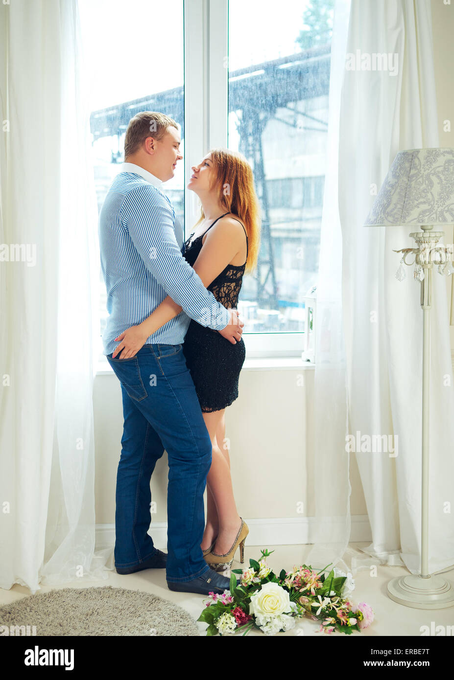 loving mature couple in front of window embrace Stock Photo
