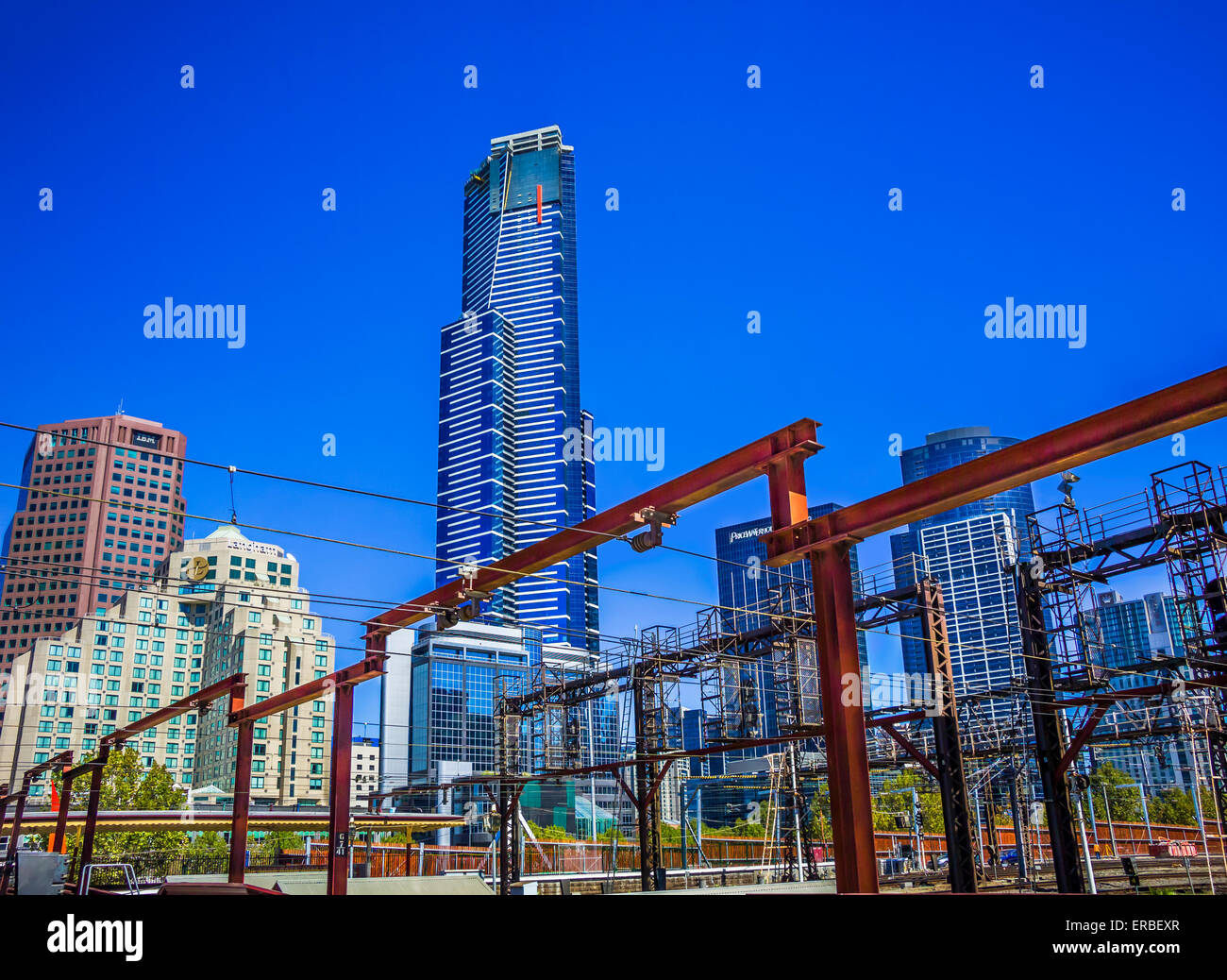 Flinders Street railway line and steel gantry against background of modern city skyscrapers, Melbourne Australia Stock Photo