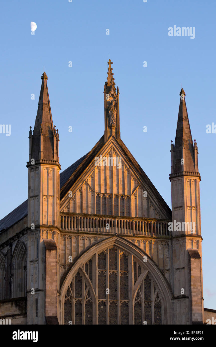 The western facade (or west front) of the gothic Winchester Cathedral at dusk with the moon overhead, Hampshire, UK Stock Photo