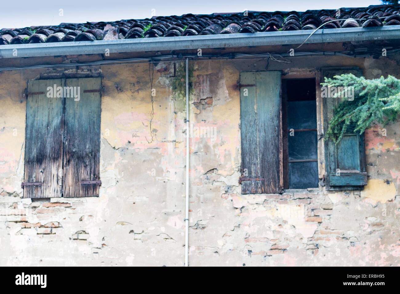 Rusty windows in ruined wall of an old farmhouse in countryside in Emilia Romagna in Italy Stock Photo