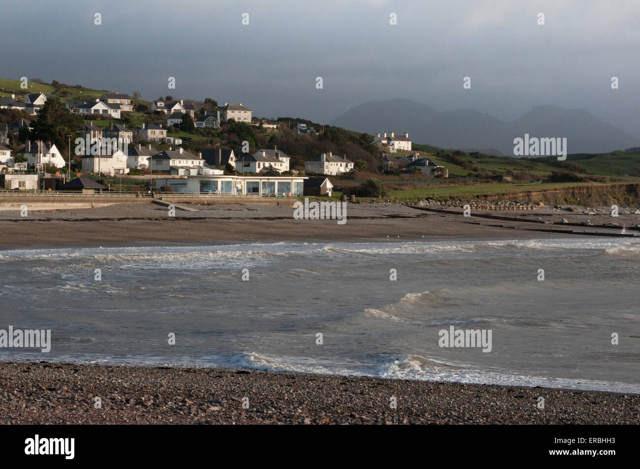 Criccieth bay with Morannedd Cafe sunlit on a stormy day Stock Photo