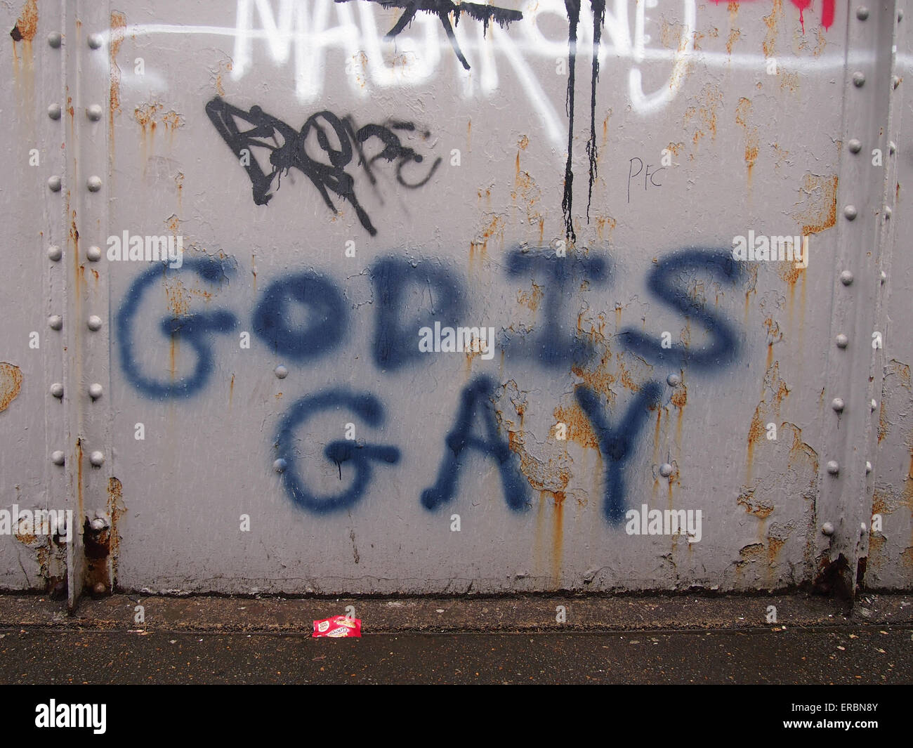 Graffiti on a railway bridge proclaiming that 'God is gay' Stock Photo
