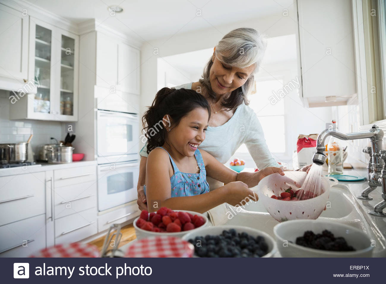 Grandmother and granddaughter making fresh jam in kitchen Stock Photo