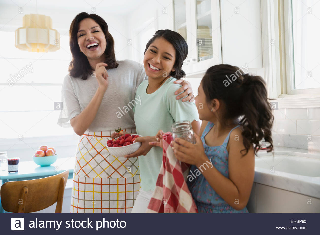 Laughing mother and daughters in kitchen Stock Photo