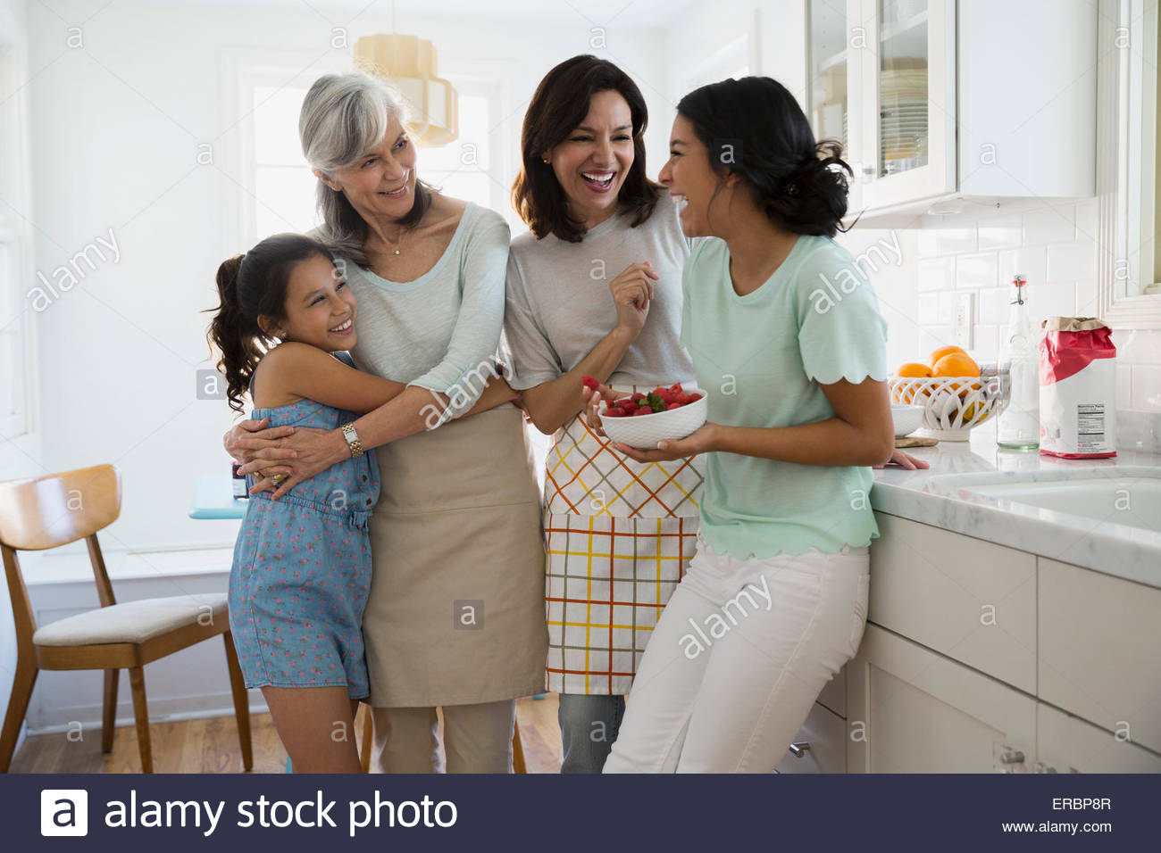 Multi-generation women laughing in kitchen Stock Photo