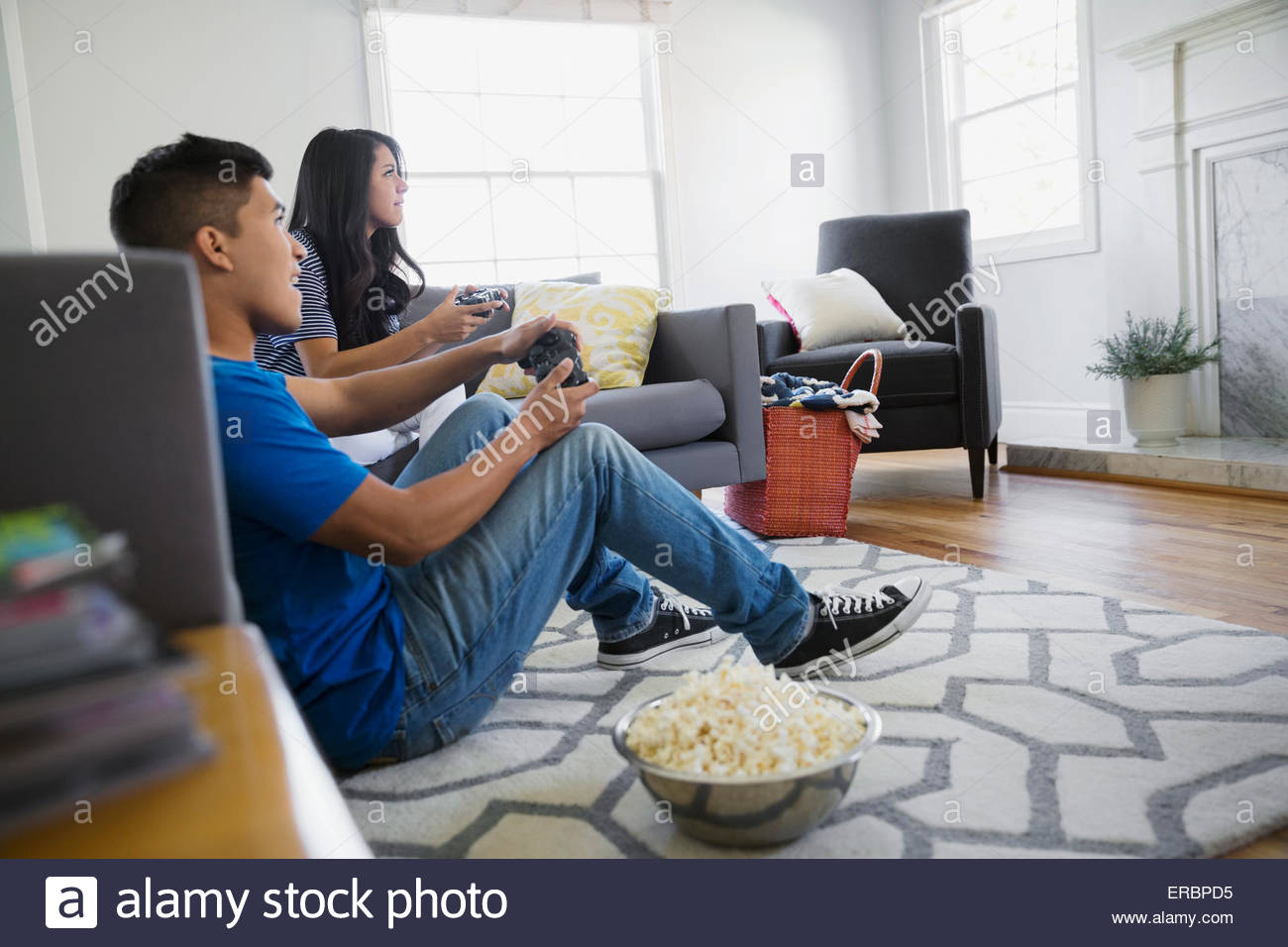 Teenage brother sister playing video game living room Stock Photo