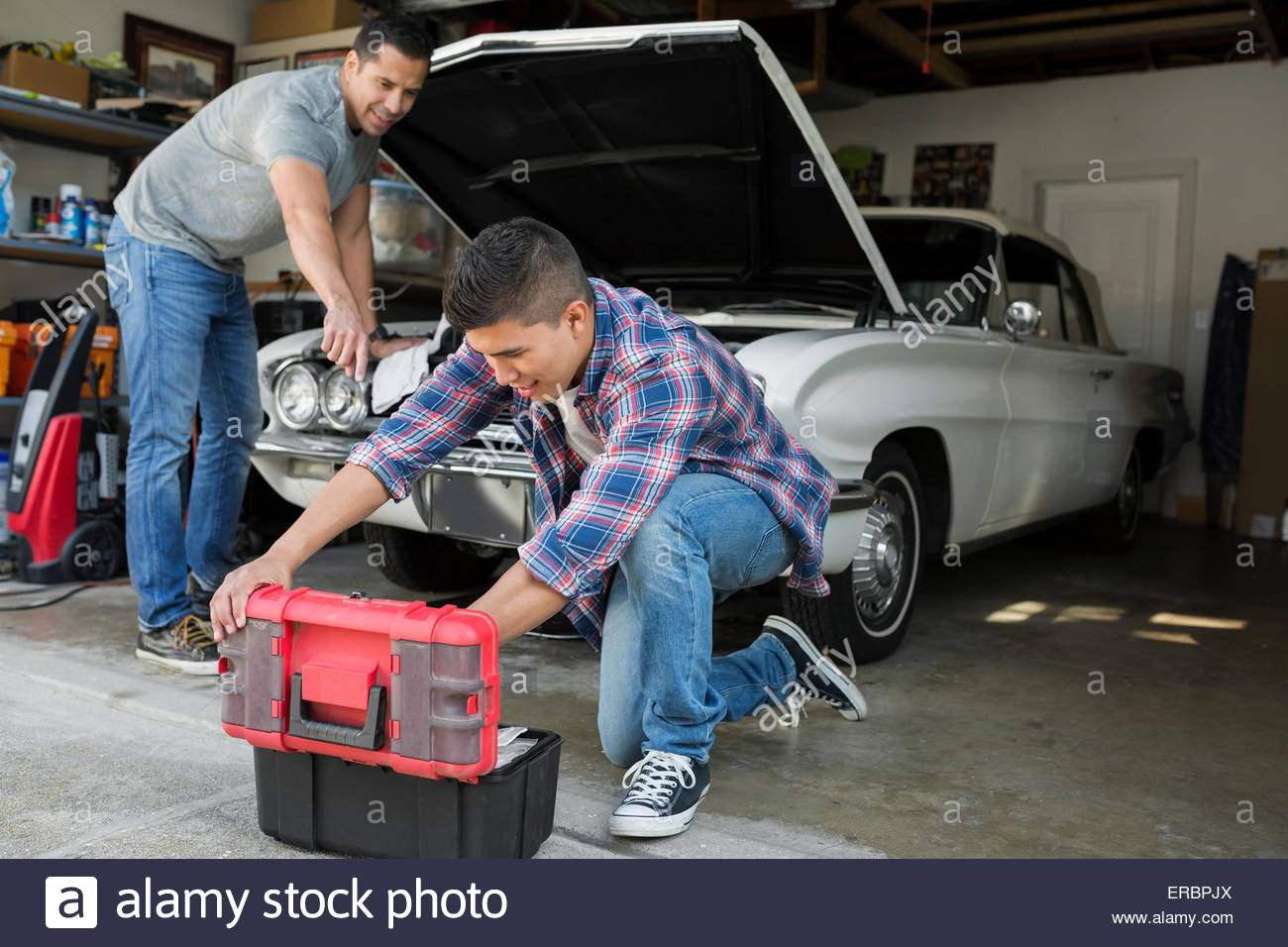 Father and son restoring vintage car engine garage Stock Photo