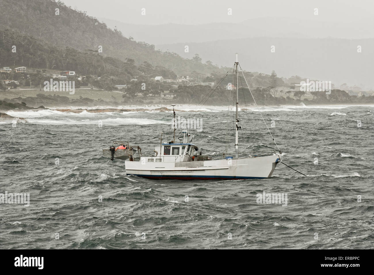 fishing boat in rough weather moored near the beach Stock Photo Alamy