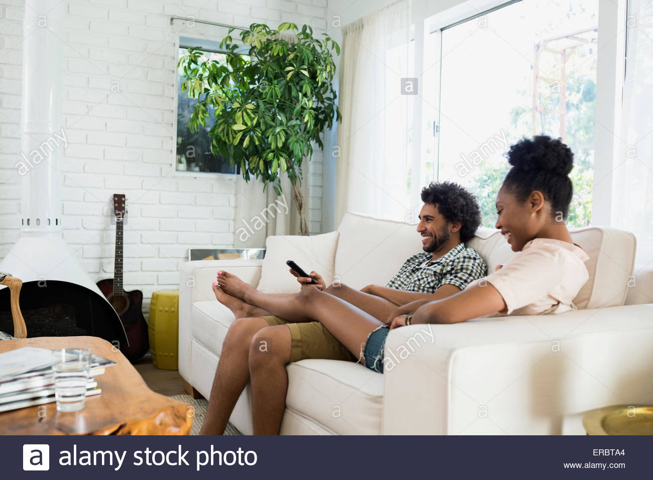 Casual couple relaxing watching TV in living room Stock Photo