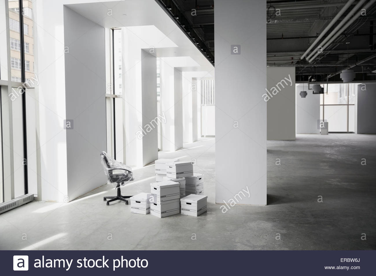 Office chair and boxes in empty office Stock Photo Alamy