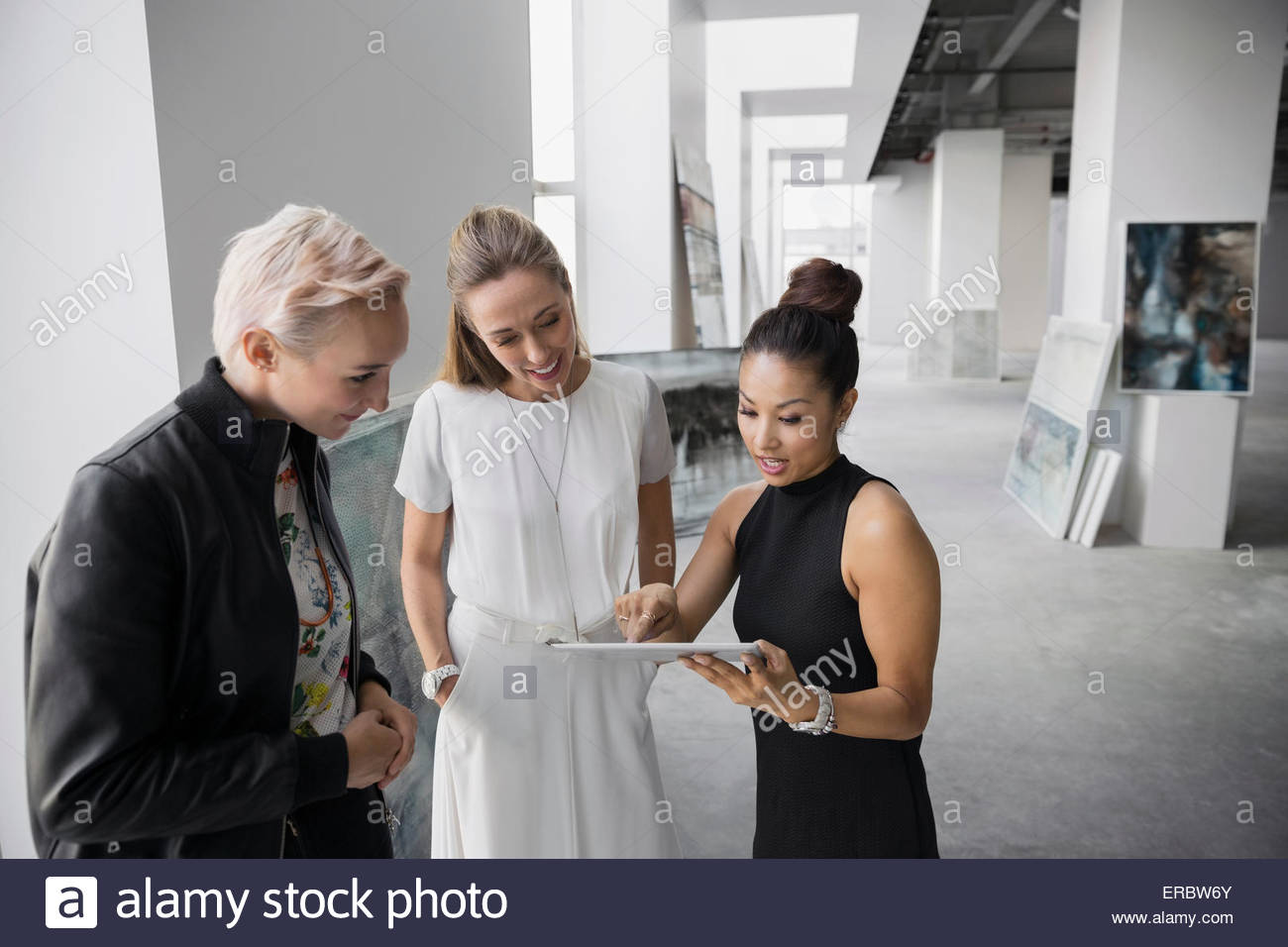 Artist and art dealers using digital tablet gallery Stock Photo Alamy