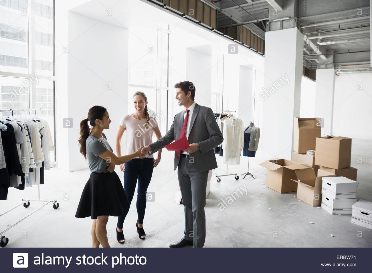Fashion stylist and businessman handshaking in studio Stock Photo