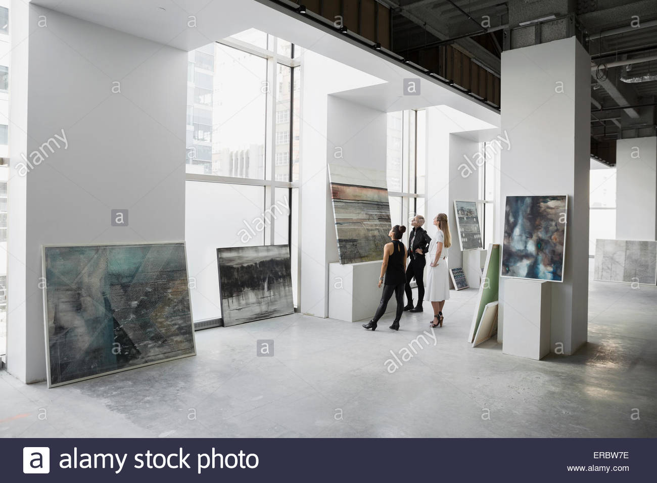 Art dealers examining painting in art gallery Stock Photo Alamy