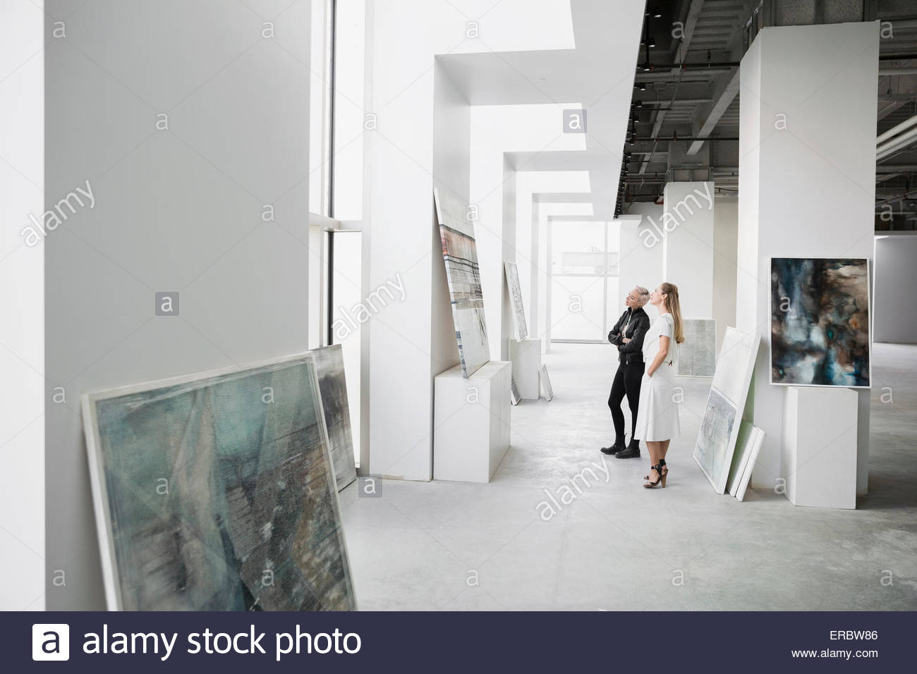 Art dealers examining painting in art gallery Stock Photo Alamy