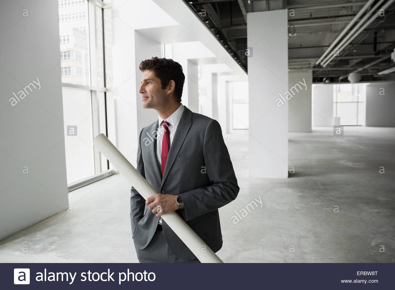 Architect holding blueprints in empty office Stock Photo