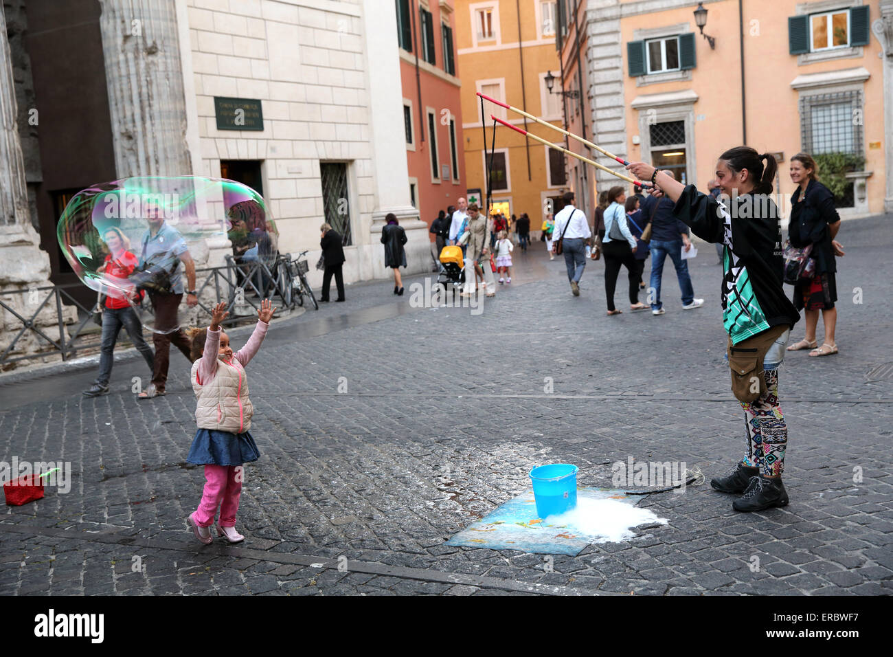 Woman creating large bubbles to the delight of children in Rome Italy Stock Photo