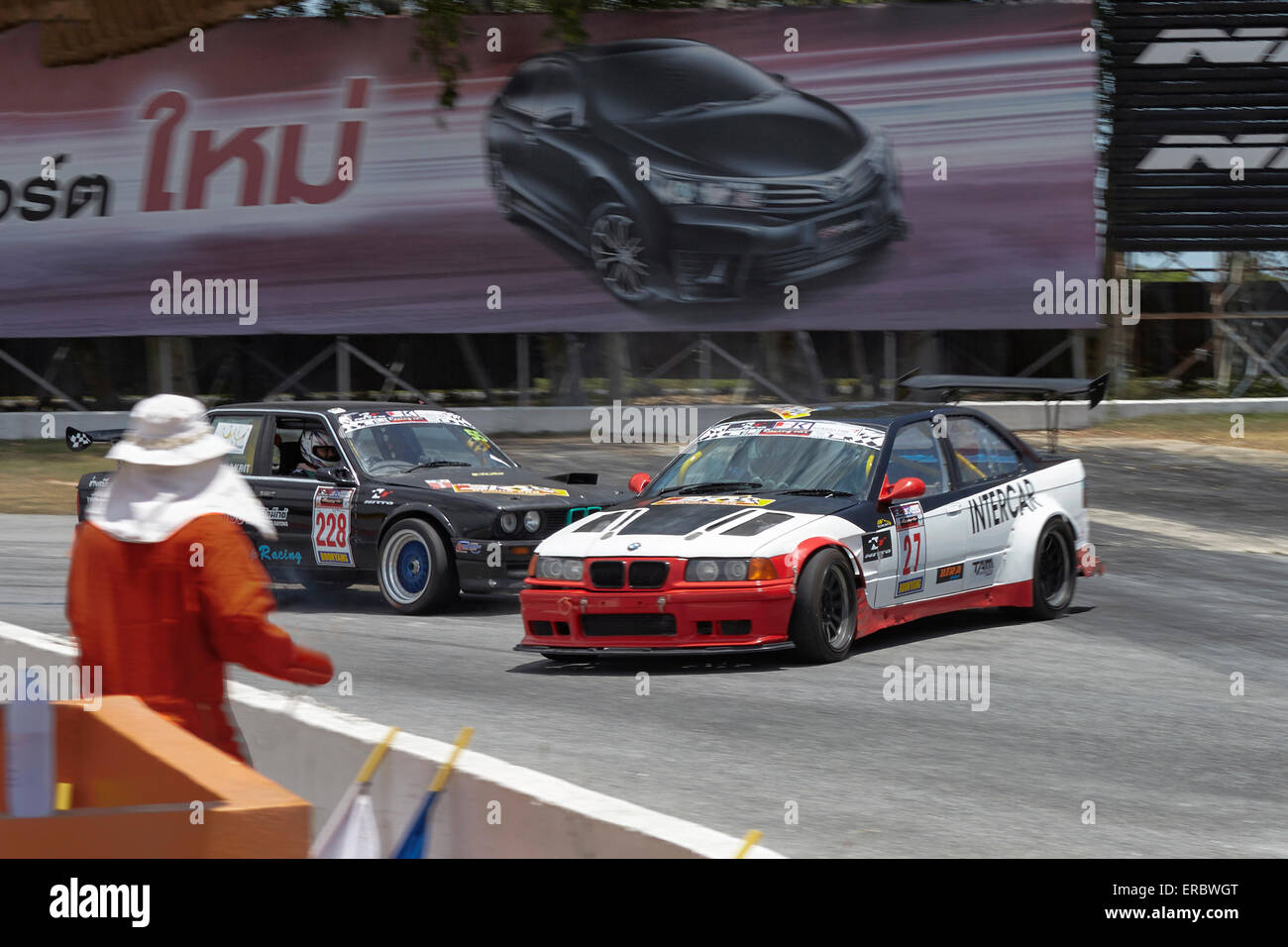 Motorsport action. Race car spinning out of control against an ironic vehicle advertisement background. Stock Photo