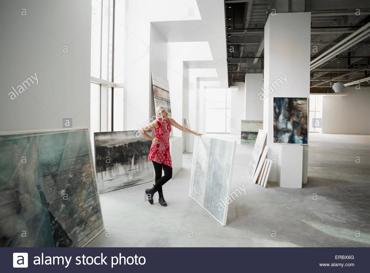 Art dealer viewing painting in art gallery Stock Photo Alamy