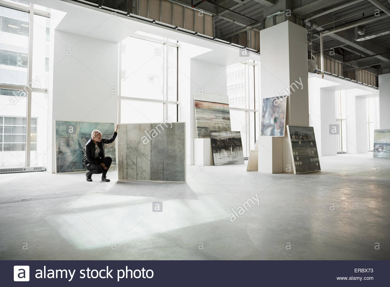 Art dealer examining painting in art gallery Stock Photo Alamy