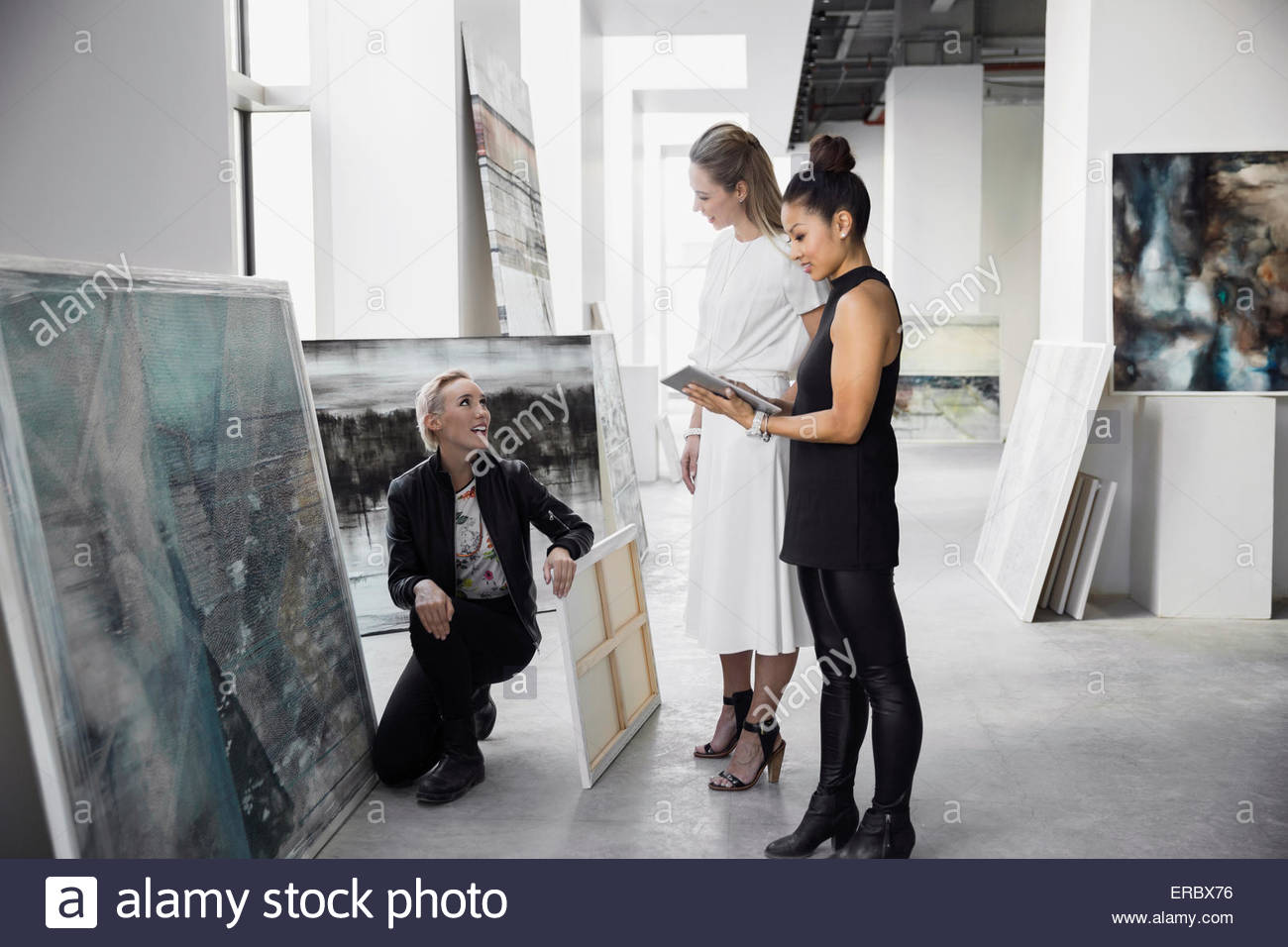 Artist and art dealers with paintings digital tablet Stock Photo Alamy
