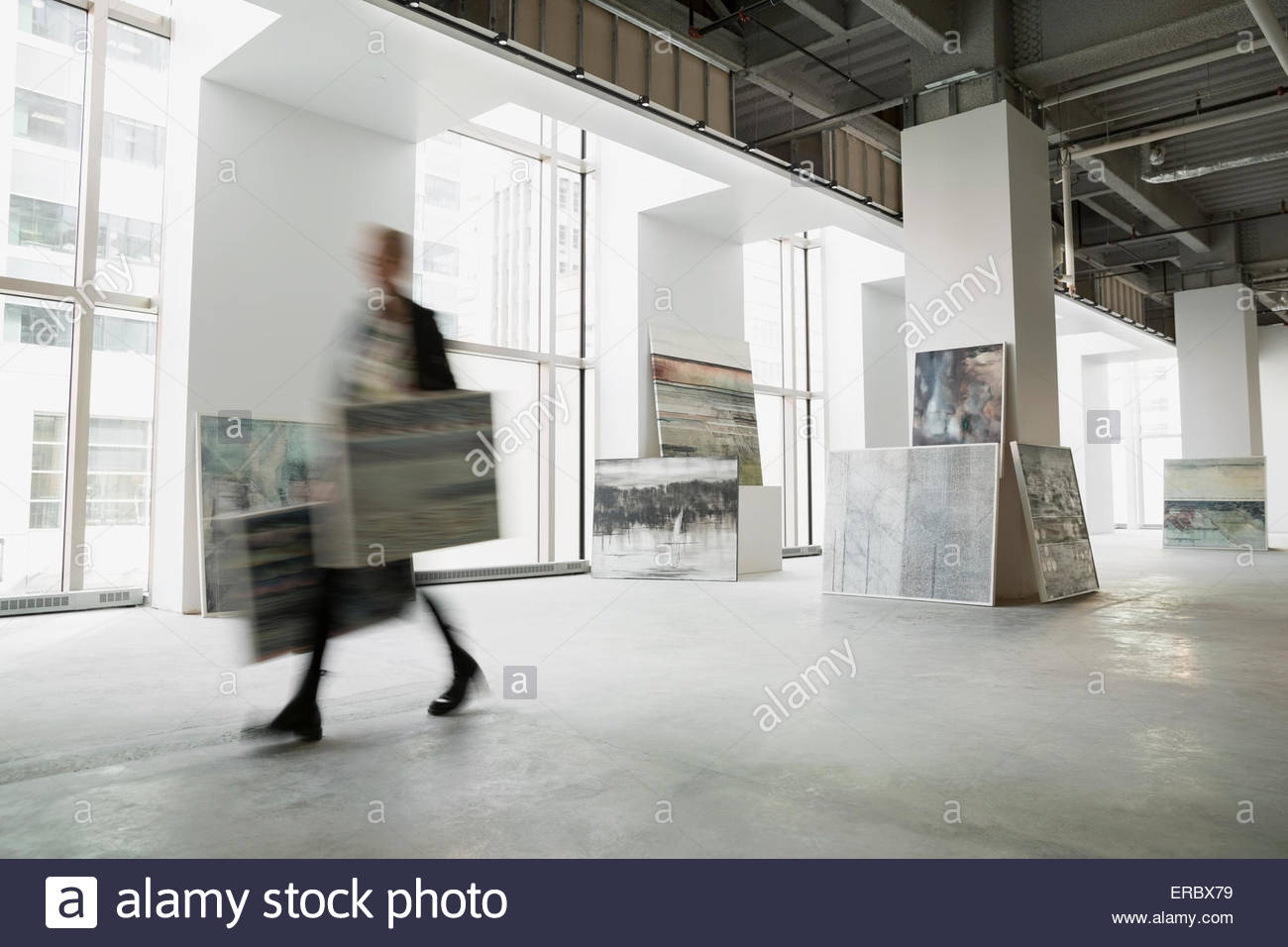 Art dealer walking with paintings in art gallery Stock Photo Alamy