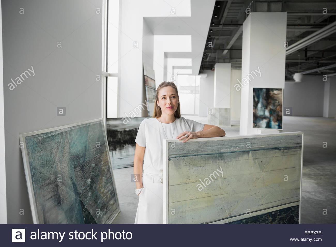 Portrait art dealer with paintings in art gallery Stock Photo Alamy